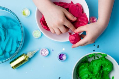 Çocuk elleri renkli kille oynuyor. Ev yapımı plastik. Plastiksin. Hamur oyna. Kil kalıbı yapan kız. Ev yapımı kil.