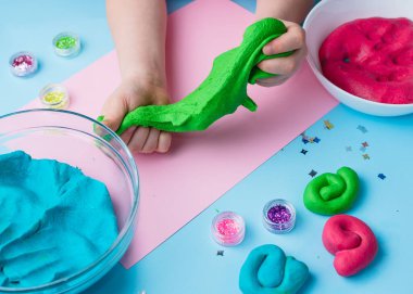 Çocuk elleri renkli kille oynuyor. Ev yapımı plastik. Plastiksin. Hamur oyna. Kil kalıbı yapan kız. Ev yapımı kil.