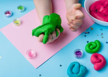 Çocuk elleri renkli kille oynuyor. Ev yapımı plastik. Plastiksin. Hamur oyna. Kil kalıbı yapan kız. Ev yapımı kil.
