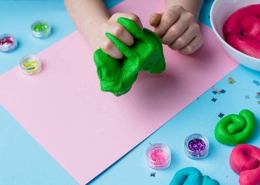 Çocuk elleri renkli kille oynuyor. Ev yapımı plastik. Plastiksin. Hamur oyna. Kil kalıbı yapan kız. Ev yapımı kil.