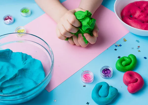 Çocuk elleri renkli kille oynuyor. Ev yapımı plastik. Plastiksin. Hamur oyna. Kil kalıbı yapan kız. Ev yapımı kil.