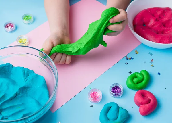 Çocuk elleri renkli kille oynuyor. Ev yapımı plastik. Plastiksin. Hamur oyna. Kil kalıbı yapan kız. Ev yapımı kil.