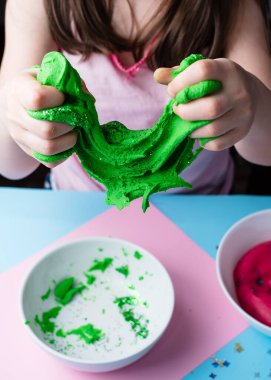 Çocuk elleri renkli kille oynuyor. Ev yapımı plastik. Plastiksin. Hamur oyna. Kil kalıbı yapan kız. Ev yapımı kil.