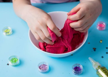 Çocuk elleri renkli kille oynuyor. Ev yapımı plastik. Plastiksin. Hamur oyna. Kil kalıbı yapan kız. Ev yapımı kil.