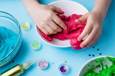 Çocuk elleri renkli kille oynuyor. Ev yapımı plastik. Plastiksin. Hamur oyna. Kil kalıbı yapan kız. Ev yapımı kil.