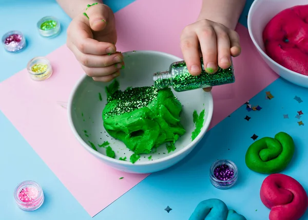 Çocuk elleri renkli kille oynuyor. Ev yapımı plastik. Plastiksin. Hamur oyna. Kil kalıbı yapan kız. Ev yapımı kil.