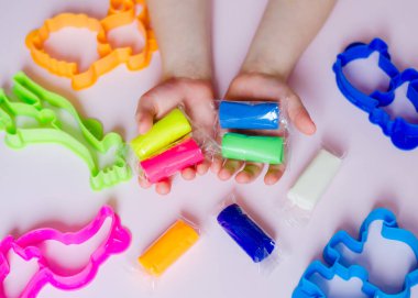 Çocuk elleri renkli kille oynuyor. Ev yapımı plastik. Plastiksin. Hamur oyna. Kil kalıbı yapan kız. Ev yapımı kil.
