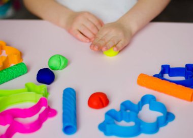 Çocuk elleri renkli kille oynuyor. Ev yapımı plastik. Plastiksin. Hamur oyna. Kil kalıbı yapan kız. Ev yapımı kil.