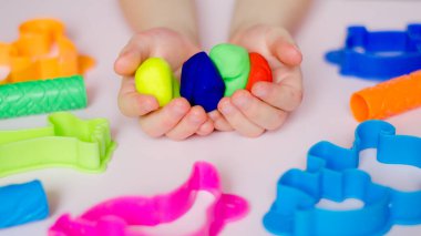 Çocuk elleri renkli kille oynuyor. Ev yapımı plastik. Plastiksin. Hamur oyna. Kil kalıbı yapan kız. Ev yapımı kil.