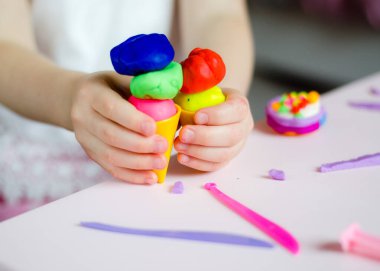 Çocuk elleri renkli kille oynuyor. Ev yapımı plastik. Plastiksin. Hamur oyna. Kil kalıbı yapan kız. Ev yapımı kil.