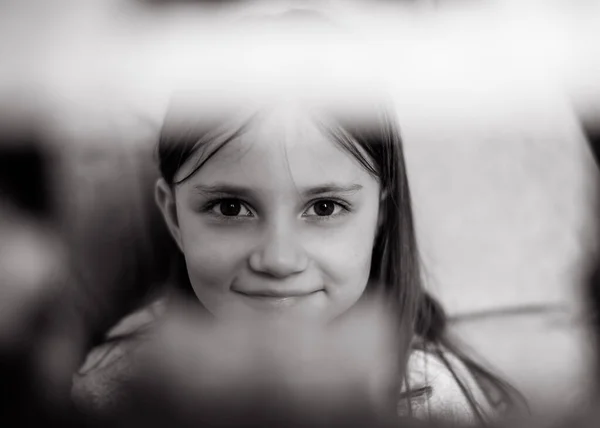Portrait of a 5 years old girl who is building a house of blocks, a constructor. Black and white photo