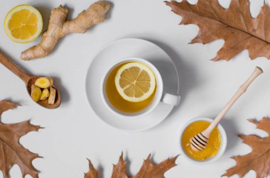 Beyaz arka planda limonlu çay, zencefil ve bal. Düz yatıyordu