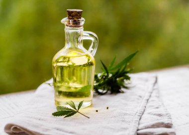 CBD kenevir ürünleri. Esrardan taze yapraklarla dolu bir şişede tıbbi esrarın temel yağı. Seçici yumuşak odaklanma. Kapat.