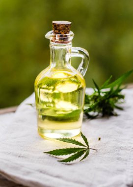 CBD kenevir ürünleri. Esrardan taze yapraklarla dolu bir şişede tıbbi esrarın temel yağı. Seçici yumuşak odaklanma. Kapat.