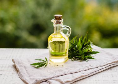 CBD kenevir ürünleri. Esrardan taze yapraklarla dolu bir şişede tıbbi esrarın temel yağı. Seçici yumuşak odaklanma. Kapat.