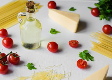 Pişmemiş makarna. Beyaz arka planda makarna pişirmek için malzemeli kiraz domatesleri. Yakın çekim