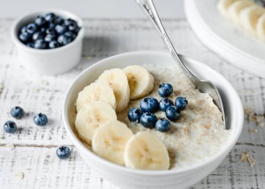 Sağlıklı kahvaltı. Bal, böğürtlen ve çay dolu bir kasede yulaf lapası. Yakın plan.