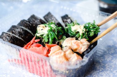 Taze ve lezzetli maki ve nigiri sushi. Plastik kutuda suşi var. Teslimat konsepti