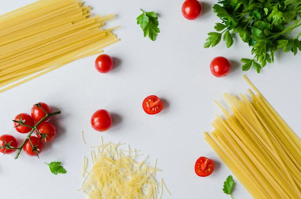 stock image Uncooked pasta. cherry tomatoes with ingredients for cooking pasta on a white background. closeup