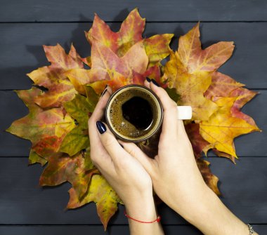 Bir fincan kahve ellerini tutarak