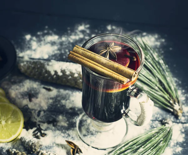 Glass hot Mulled wine with sticks of cinnamon, anise, lemon — Stock Photo, Image