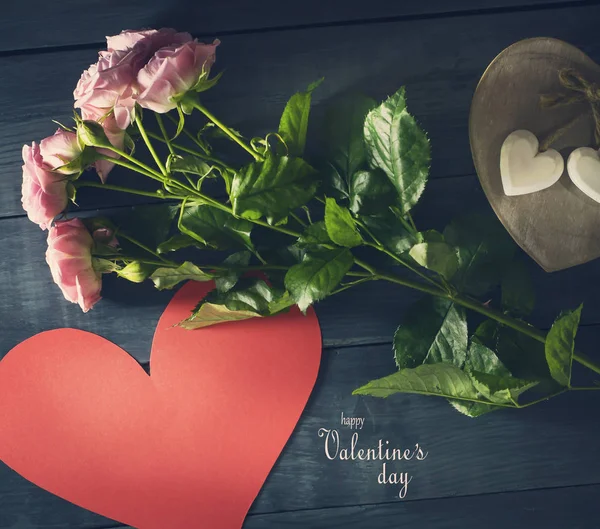 Bouquet di rose con cuore di carta su sfondo di legno blu . — Foto Stock