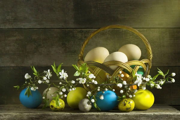Eski bir ahşap arka plan üzerinde renkli yumurtalı Paskalya natürmort — Stok fotoğraf