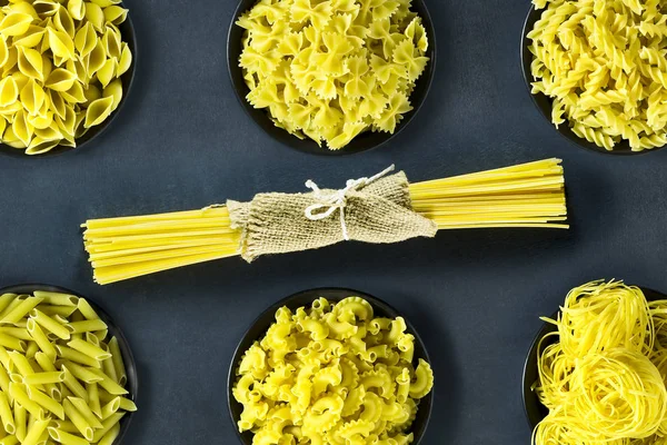 Secar la pasta italiana en un bol sobre un fondo azul oscuro . — Foto de Stock