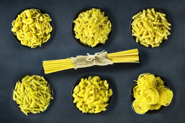 Secar la pasta italiana en un bol sobre un fondo azul oscuro . — Foto de Stock