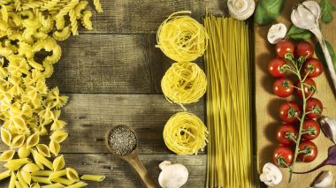 İtalyan makarna, cherry domates, sarımsak, mantar ve baharat bir rustik ahşap tablo.