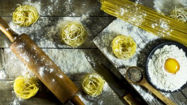 İtalyan makarna, un ve rustik ahşap bir masa üzerinde çiğ yumurta.