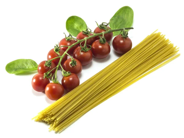 Cherry Tomaten met droge Italiaanse pasta op een witte achtergrond. — Stockfoto