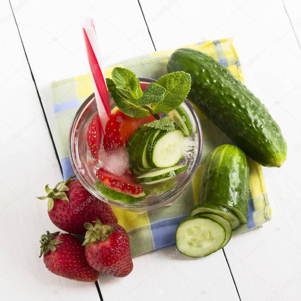 A glass of detox water with strawberries, ice and fresh cucumber. Healthy lifestyle.