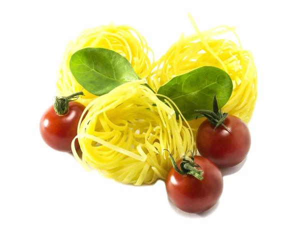 Kirschtomaten mit trockener italienischer Pasta auf weißem Hintergrund. — Stockfoto