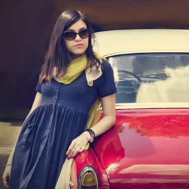 Bir retro car yakınındaki güzel genç bayan.