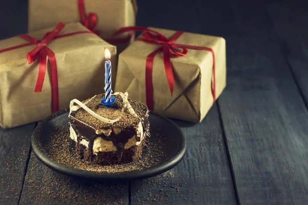 Bir mum ve hediyeler ile çikolatalı kek. Mutlu yıllar, kart. Tatil tebrik kartı. — Stok fotoğraf