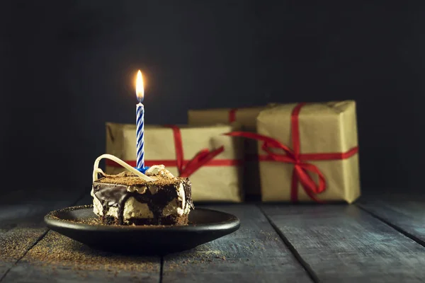 Pastel de chocolate con una vela y regalos.Feliz cumpleaños, tarjeta. Tarjeta de felicitación de vacaciones . —  Fotos de Stock