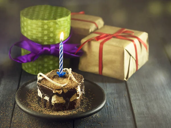 Bolo de chocolate com uma vela e presentes.Feliz aniversário, cartão. Feriados cartão de saudação . — Fotografia de Stock