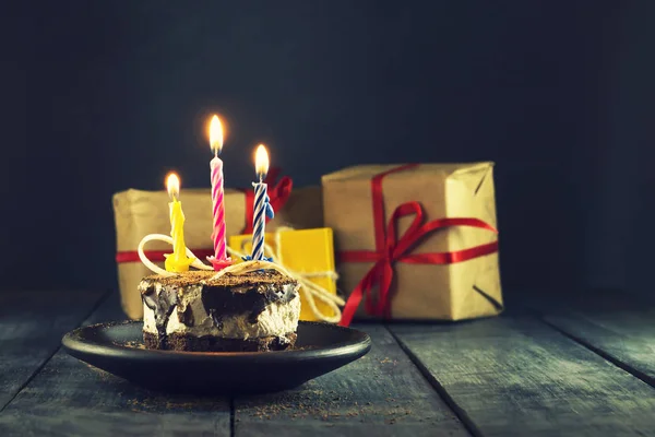 Pastel de chocolate con una vela y regalos.Feliz cumpleaños, tarjeta. Tarjeta de felicitación de vacaciones . —  Fotos de Stock