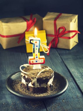 Bir mum ve hediyeler ile çikolatalı kek. Mutlu yıllar, kart. Tatil tebrik kartı.