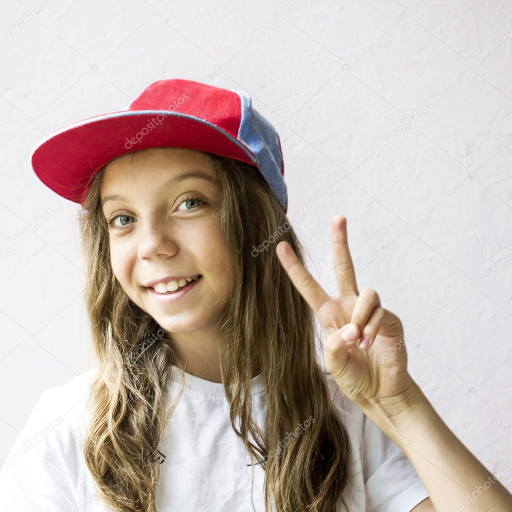 Smiling beautiful girl teenager in a baseball cap and white t-shirt