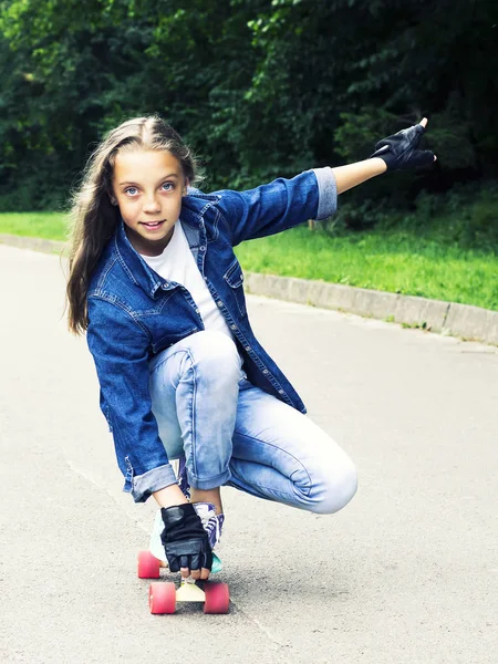 公園でスケート ボードのジーンズ シャツで美しい金髪の十代の少女 — ストック写真