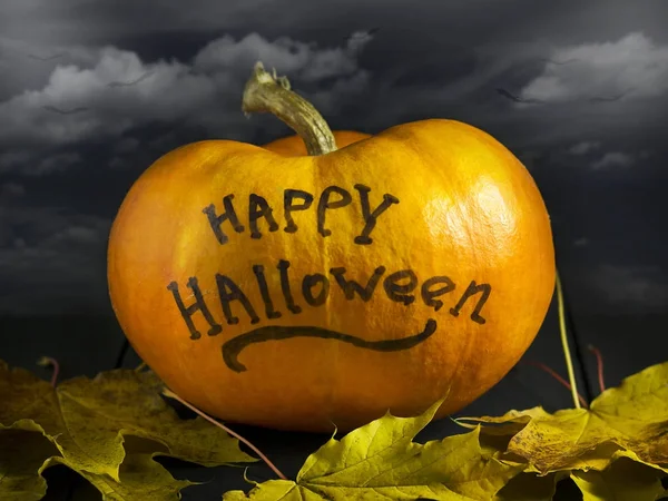Halloween pompoen op een donkere achtergrond. Met de inscriptie van happy halloween. — Stockfoto
