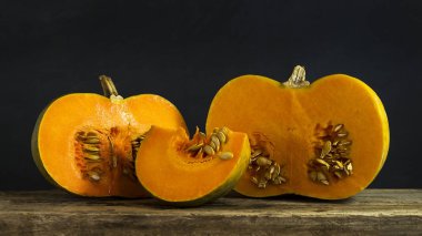 Bir ahşap tahta üzerinde bir bütün ve kesme olgun balkabağı. Sebze. Hasat.