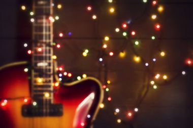 Eski elektro gitar ile karanlık bir arka plan üzerinde yanan bir çelenk. Odak arka plan dışarı. Tebrik, Noel, yeni yıl tebrik kartı. Kopya alanı.