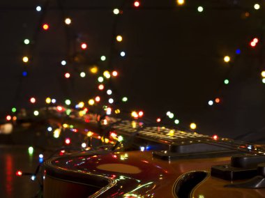 Eski elektro gitar ile karanlık bir arka plan üzerinde yanan bir çelenk. Tebrik, Noel, yeni yıl tebrik kartı. Kopya alanı.