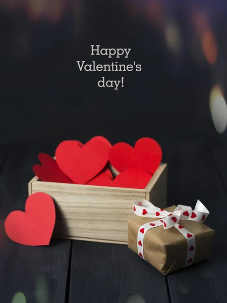Cuori di carta rossa in una scatola di legno. Fondo in legno scuro. Ricevuto. Giorno di S. Valentino . — Foto Stock