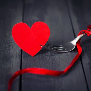 Kırmızı kağıt kalpleri ve bir çatal ile bir şerit. Koyu ahşap arka plan. Uzay kopyalayın. St. Valentine's Day.