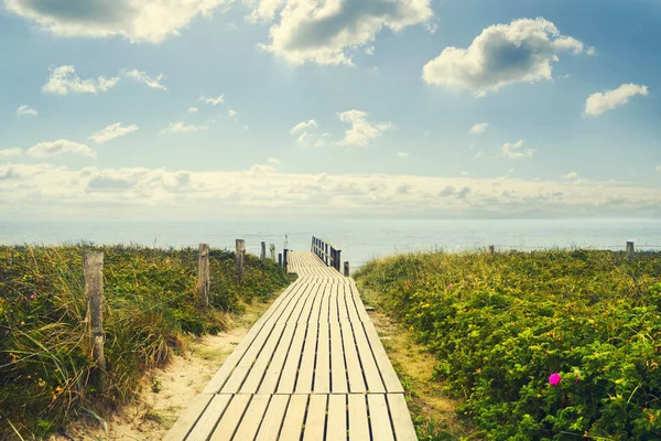 Wooden bridge to the sea. The sky with beautiful clouds. Recreation.Travel.