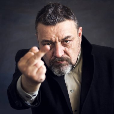 Siyah takım elbise gösteren orta parmak kızgın sakallı adam. Kopya alanı.